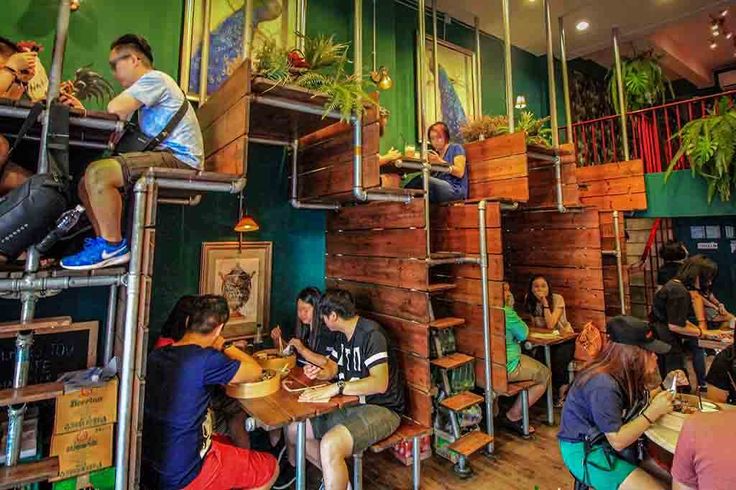 Cafes In Meiner Nähe Jetzt Geöffnet people sitting at tables in a restaurant with green walls and plants on